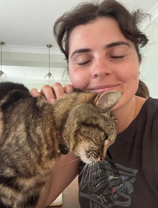 Jo sharing a cuddle with a tabby cat